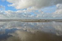 Weerspiegeling van wolken in water van de Noordzee