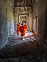 Drie jonge boeddhistische monniken gaan de Angkor Wat tempel binnen in Cambodja