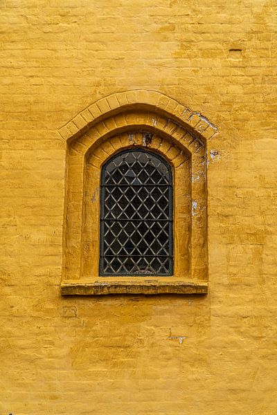 Kirchenfenster in ockerfarbener Wand. von Axel Weidner