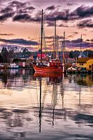 Bateau de pêche amarré dans le port et se reflétant dans l'eau
