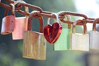 L'amour se verrouille de différentes couleurs sur une chaîne par une journée ensoleillée.