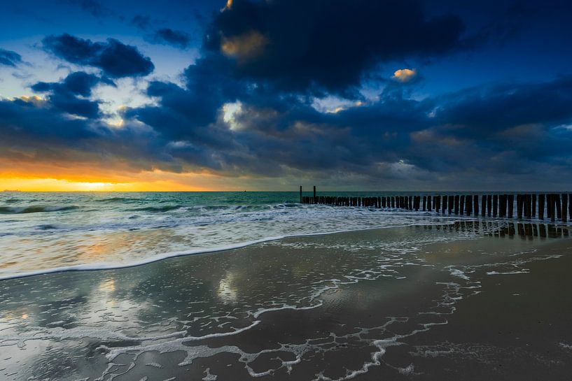 Nuages hollandais et brise-lames typiques de poteaux en bois le long de la côte zélandaise par gaps photography