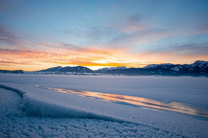 Sonnenaufgang über dem gefrorenen Forggensee und den Ostallgäuer Alpen von Leo Schindzielorz