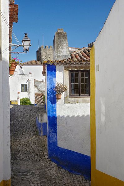 An alley in Óbidos (Portugal) in blue, yellow and white by Berthold Werner