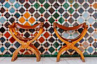 Zwei authentische Stühle vor einer Mosaikwand