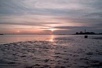Schöner Sonnenuntergang mit Reflexion auf dem Sand