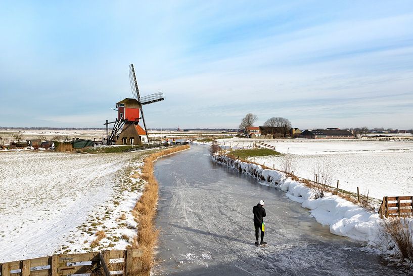 Skaten in einer niederländischen Polderlandschaft mit Blick auf eine Windmühle. von Mieneke Andeweg-van Rijn