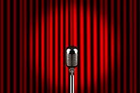 Un microphone sur une scène devant un rideau rouge