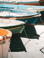 Des bateaux de pêche colorés dans le port de Procida se reflétant dans la mer