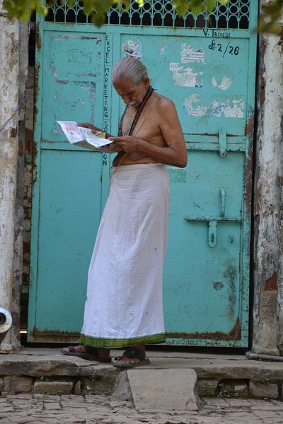 Indian man reads newspaper by Petra van der