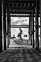 Jour de plage nuageux, femme lunatique, empreintes de pas alignées.