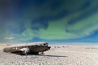 Dakota on Sólheimasandu's beach with Aurora Borealis