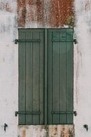 Groene luiken met verweerde witte muur op Île de Ré - Frankrijk