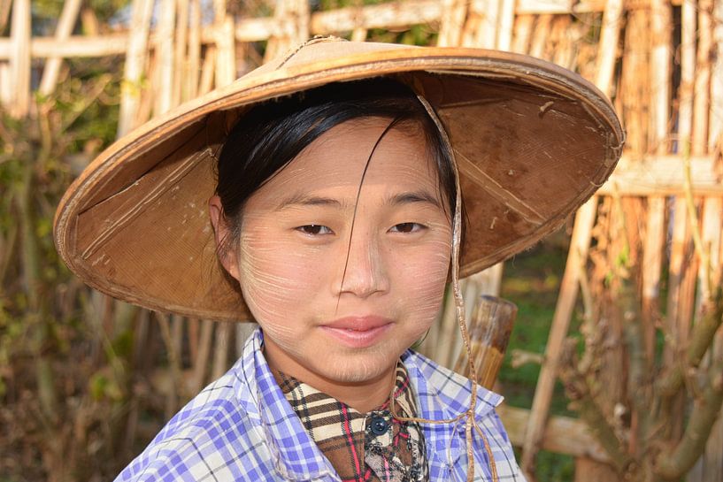 Portrait of a girl with a tanaka and a straw hat in rural Myanmar by My Footprints