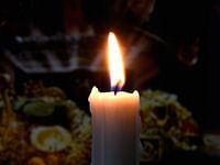 Burning candle on dark background