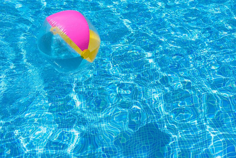 Swimming pool water surface with floating inflatabel beach ball by Alex Winter