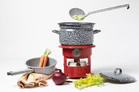 Still life / Casserole vintage sur un réchaud à pétrole rouge avec des légumes