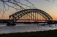 Ijsselbrug bij Zwolle met hoog water en zonsondergang