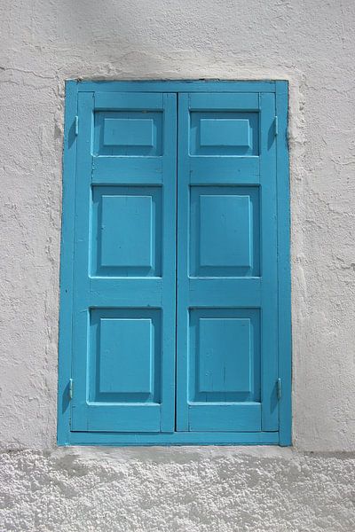 Blue window in white wall by Daniël Loman