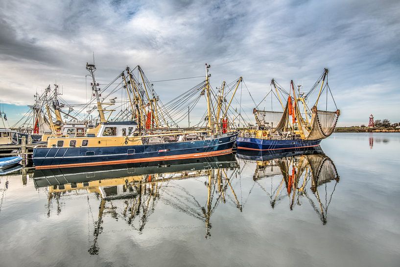 De haven van Stavoren, Friesland, op een windstille winterdag met vissersboten gespiegeld en de rode par Harrie Muis