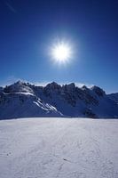 Sonne auf der Skipiste in der Axamer Lizum mit den Kalkkögeln im Hintergrund (Tirol, Österreich)