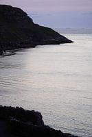 Un contraste saisissant entre les rochers et la mer au coucher du soleil