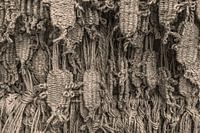 Sandales bouddistes en paille sur un mur d'offrandes.