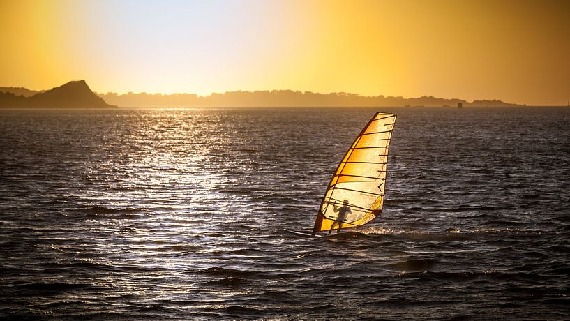 Surfer nog net even tijdens de zonsondergang van Karel Pops