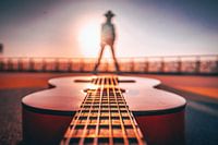 creatief concept, gitaar tijdens zonsondergang met model