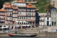 Transportkahn vor bunten Häusern im Hafen von Porto