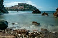 castelsardo in de zee met rotsblokken er voor