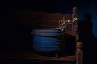 Still life of a blue kettle with seed pods of poppy