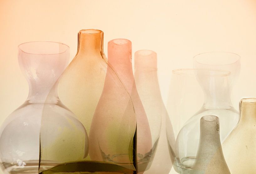 Still life of various glass bottles in warm orange, pink and green hues by Birgitte Bergman