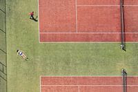 Tennisplatz aus der Vogelperspektive mit einem sonnenbadenden Mädchen und einem Tennisspieler