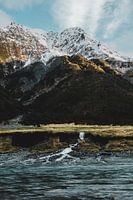 Sonnenlicht auf schneebedecktem Berg mit Wasserfall in Neuseeland