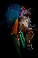 Old woman smokes traditional cheroot cigar in front of her home in Baghan in Myanmar