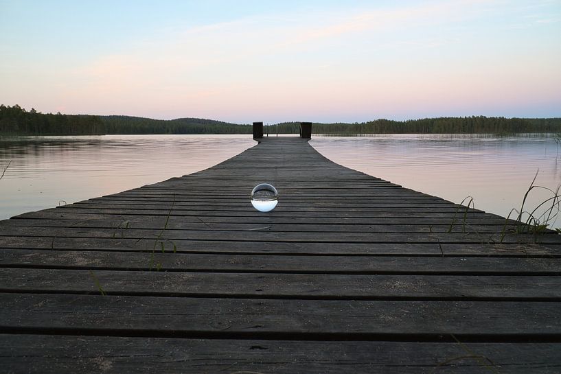 Boule de verre sur un ponton qui se jette dans un lac par Martin Köbsch