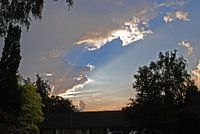 ondergaande zon schijnt tegen de onderkant wolken