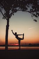 Yogapose comme silhouette au coucher du soleil
