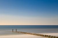 Golfbreker aan het strand in het water.