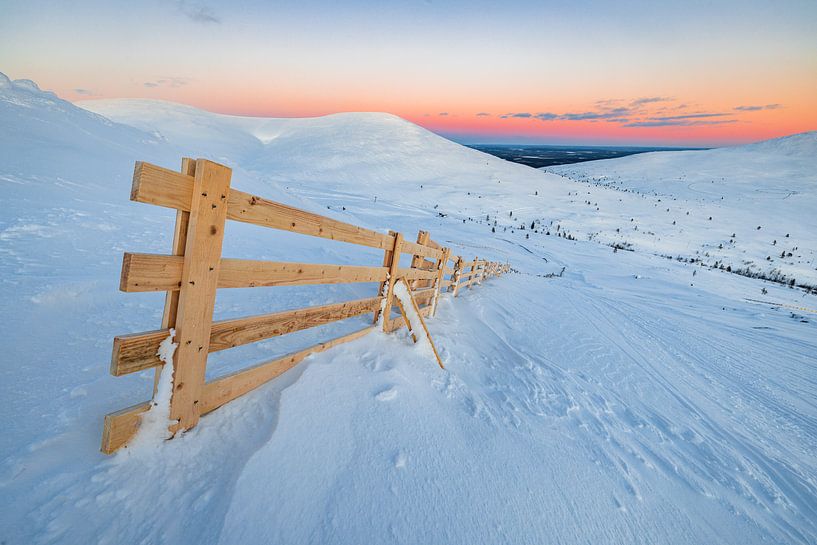 Clôture en bois au sommet d'une montagne enneigée par Martijn Smeets