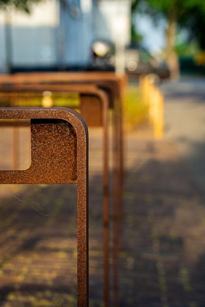 Des porte-vélos marron rouillés dans la rue par Andrea de Jong