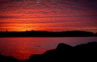 Zonsondergang in Zeeland, de wolkenlucht weerspiegeld in het water