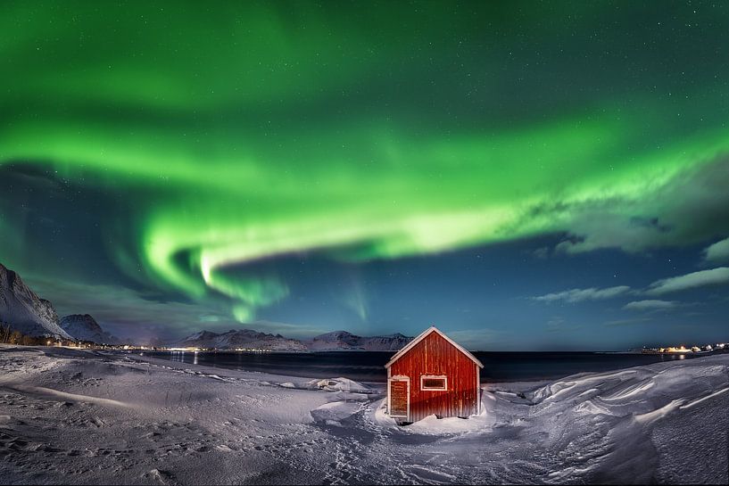 Maison en bois rouge avec aurore boréale sur les îles Lofoten en Norvège. par Voss photographie