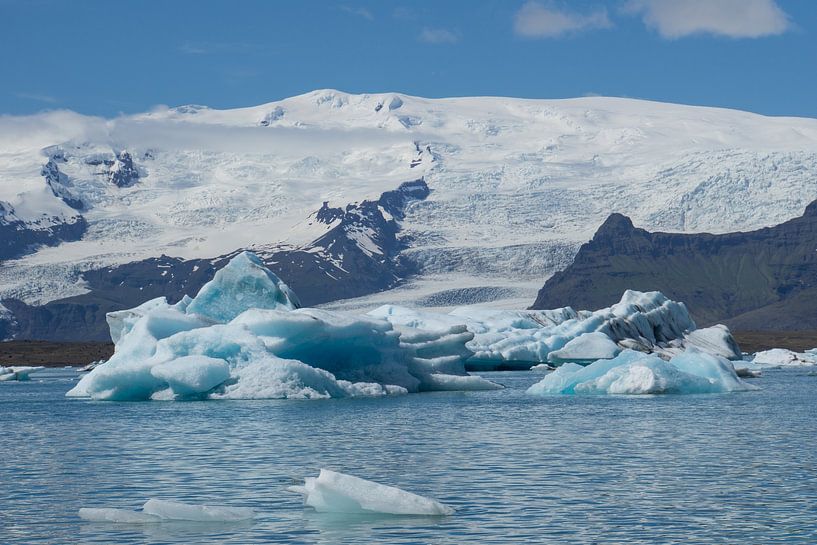 Iceland - Huge turquoise shining icebergs in glacial lake in front of massive glacier vatnajoekull by adventure-photos