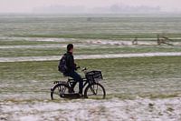 Fietser door besneeuwd landschap