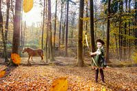 Boy plays Robin Hood in autumn forest