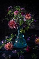 Donker stilleven van bloemen in blauwe vaas. Dark flower stilllife in a blue vase.
