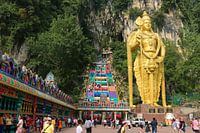 Lord Murugan avec moulins à prières et escaliers devant les Batu Caves
