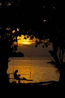 Frau auf der Schaukel bei Sonnenuntergang